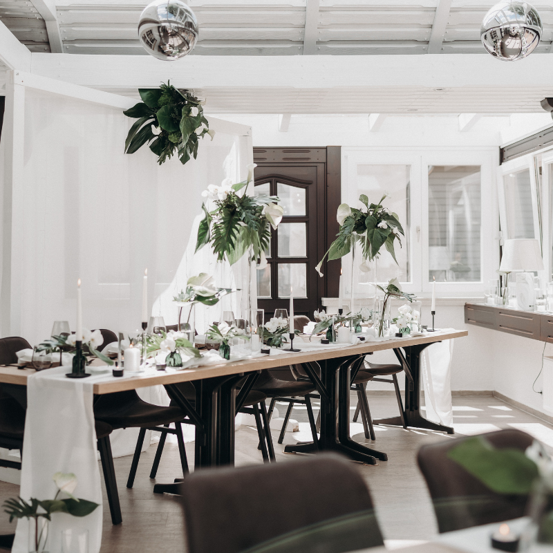 Tischdekoration bei einer Hochzeit in schwarz, weiß und grün mit tropischen Pflanzen